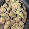 Close-up view of G13 cannabis buds, showcasing their dense structure and rich coloration in a transparent bag.