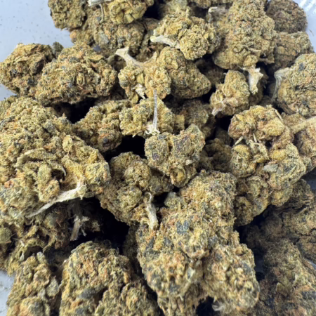 Close-up of Red Velvet cannabis buds showcasing their dense texture and vibrant green hues, ideal for connoisseurs.