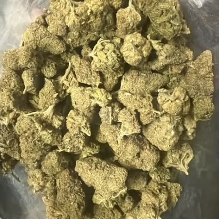 Premium quality Lime Headz cannabis buds displayed in a clear container, showcasing their rich texture and vibrant color.